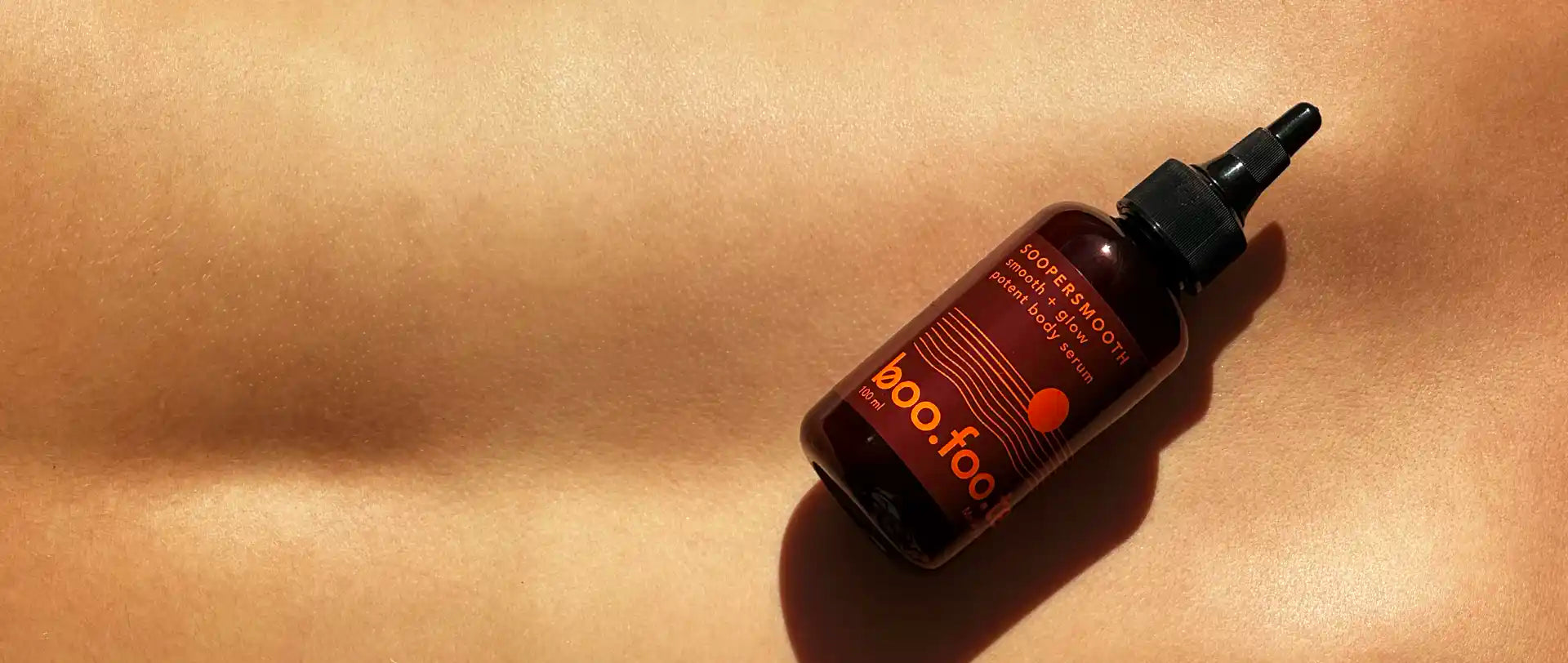 Soopersmooth body serum for bumpy skin, strawberry legs, dark patches and uneven body skin tone, held against smooth glowing skin.